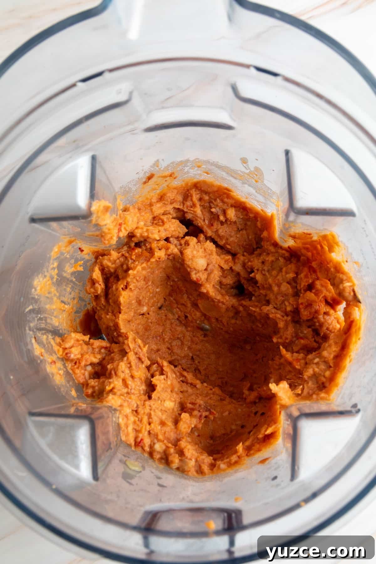Chipotle Chorizo Bean Dip Recipe — Smoky Spicy Party Dip 6 Blended chorizo bean mixture in a blender, smooth and thick with an orange-red color.