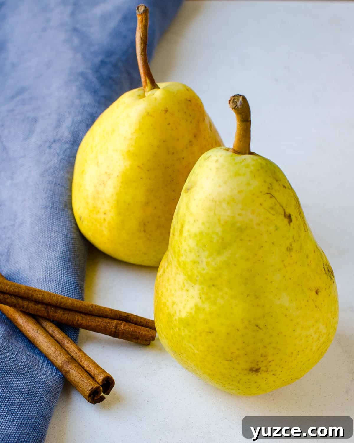 Warm Autumn-Spiced Baked Pears with Maple Glaze 2 Two pears and sticks of cinnamon.