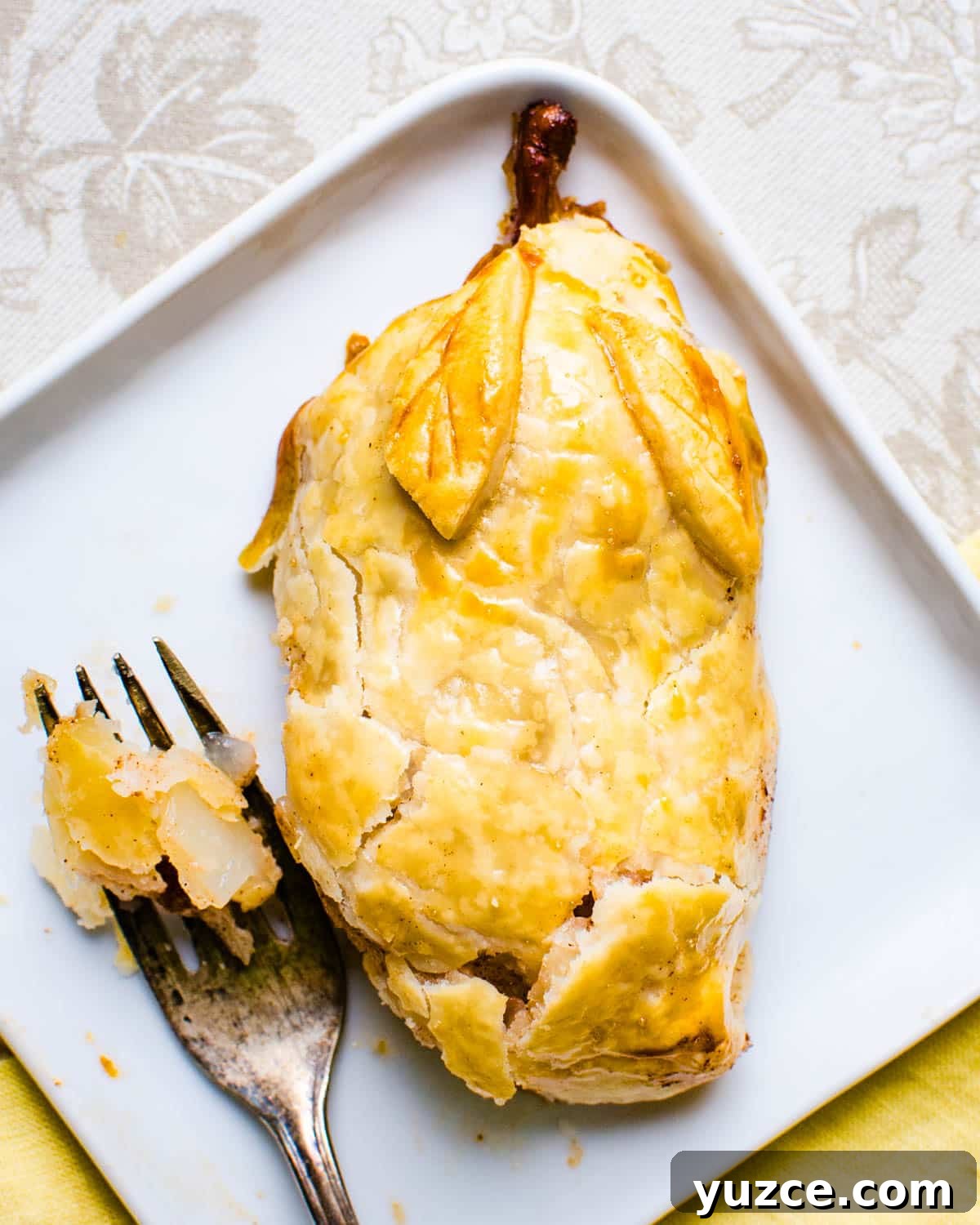 Warm Autumn-Spiced Baked Pears with Maple Glaze 7 A pastry baked pear on a plate.