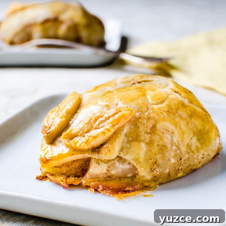 Warm Autumn-Spiced Baked Pears with Maple Glaze 9 A baked pear covered in pastry on a plate.