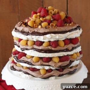 Hazelnut Meringue Cake Recipe with Crispy Layers and Creamy Filling 4 Close up of a Hazelnut Meringue Cake on a white platter.