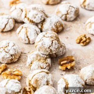Gluten-Free Walnut Cookie Recipe — Crunchy Homemade Treat 13 Baked Walnut Cookies on some baking paper, with some pieces of walnut sprinkled around.