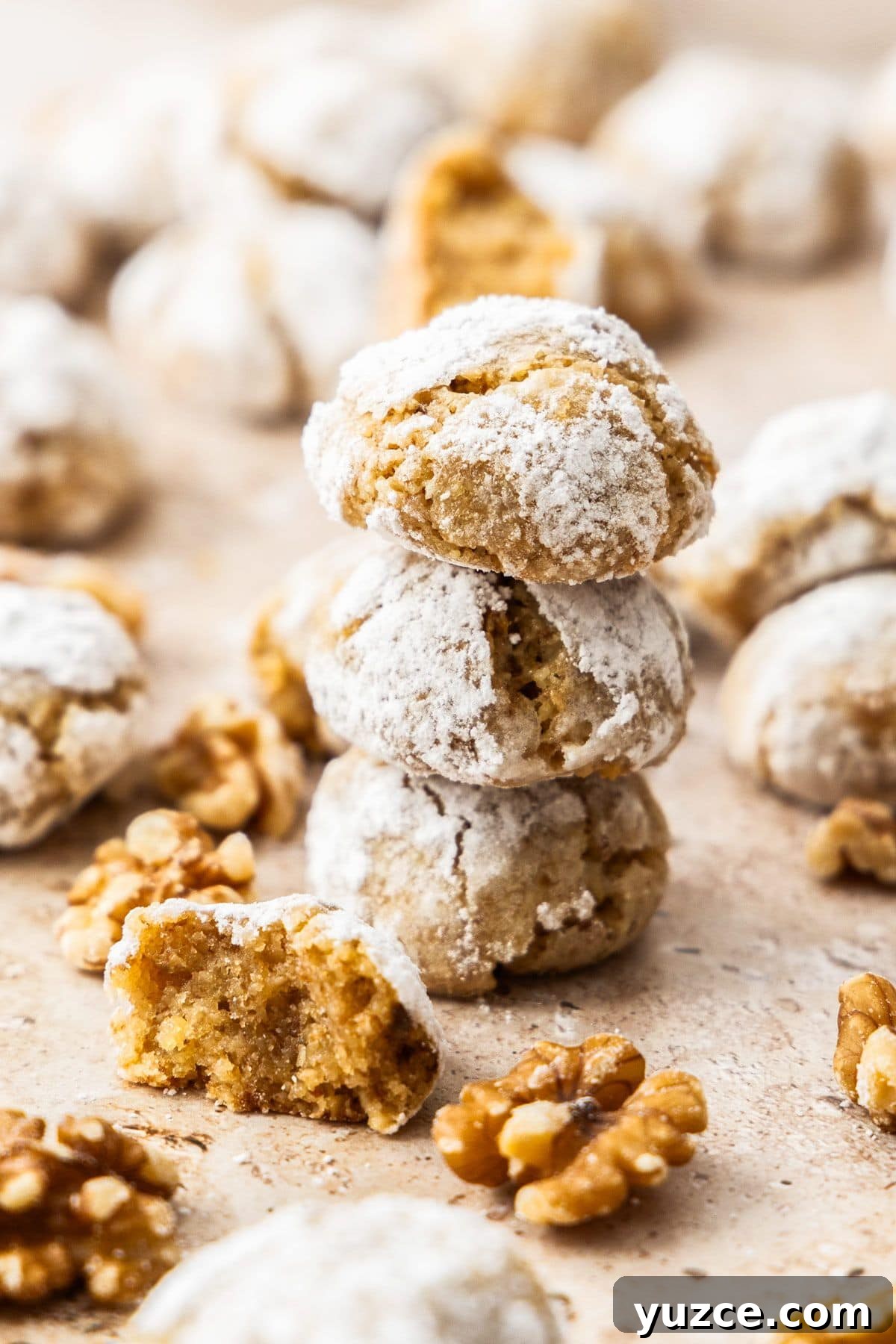 Gluten-Free Walnut Cookie Recipe — Crunchy Homemade Treat 7 Stack of three Walnut Cookies, with more cookies spread on a baking tray.