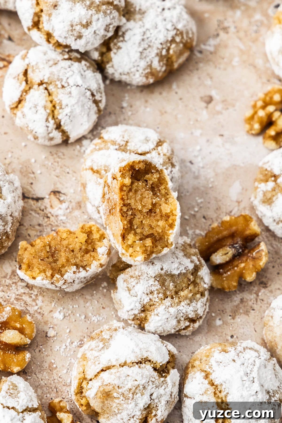 Gluten-Free Walnut Cookie Recipe — Crunchy Homemade Treat 8 Baked Walnut Cookies on a baking paper lined tray, with one broken in half.