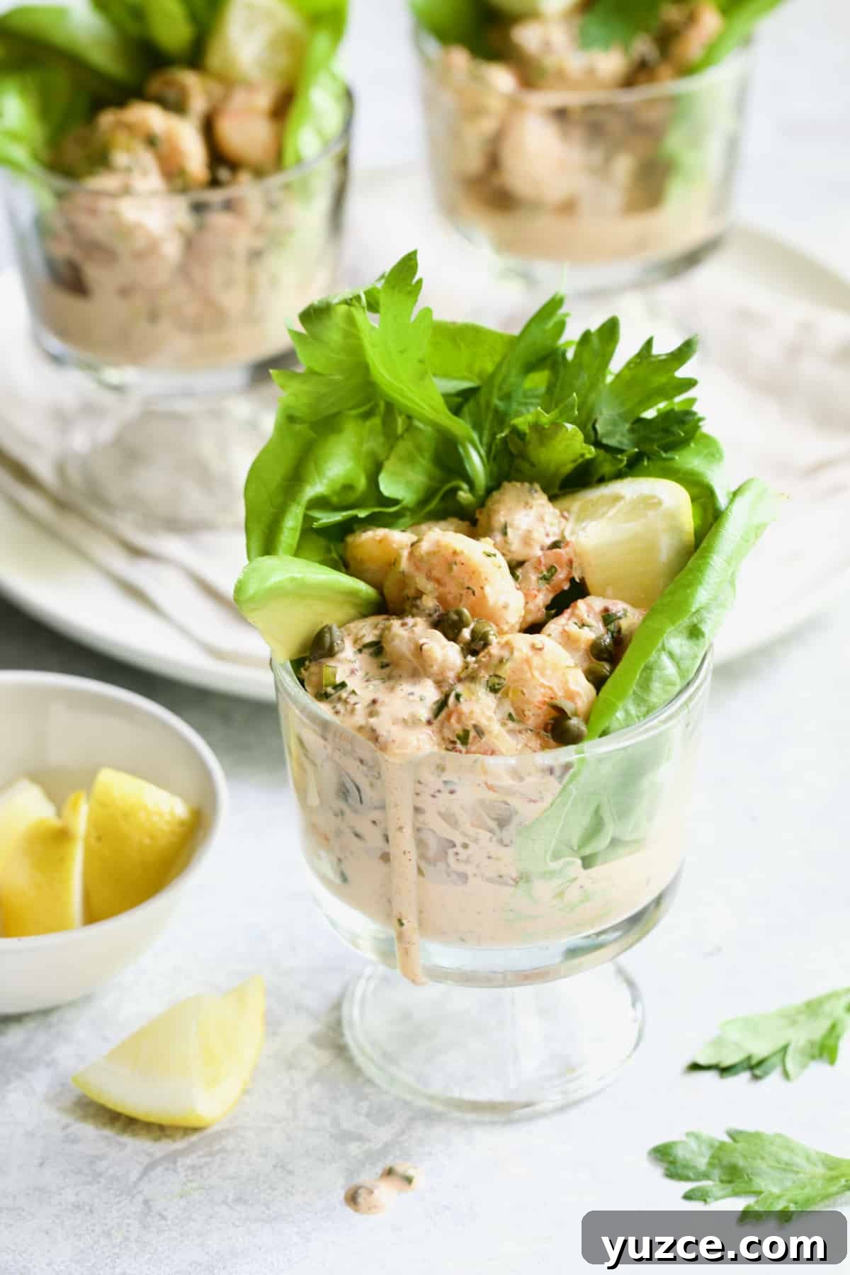 Shrimp Cocktail with Sriracha Remoulade Sauce 8 Sriracha Shrimp Remoulade Cocktail with lemon wedge and celery leaves.