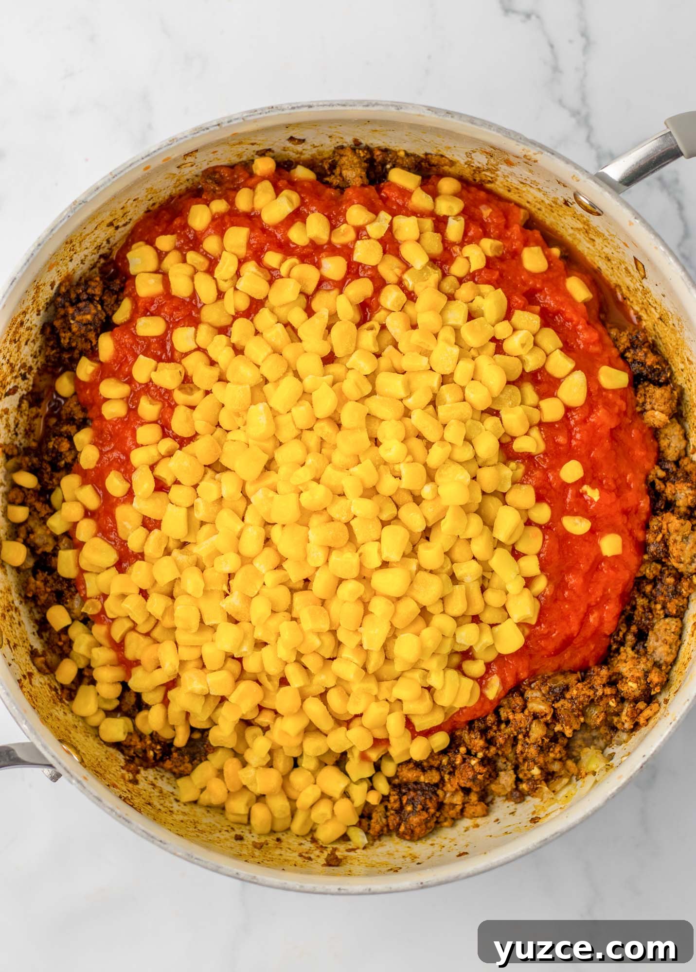 Creamy Cornbread Casserole with Cheesy Corn Topping 5 Added tomato sauce and corn to a skillet of browned beef