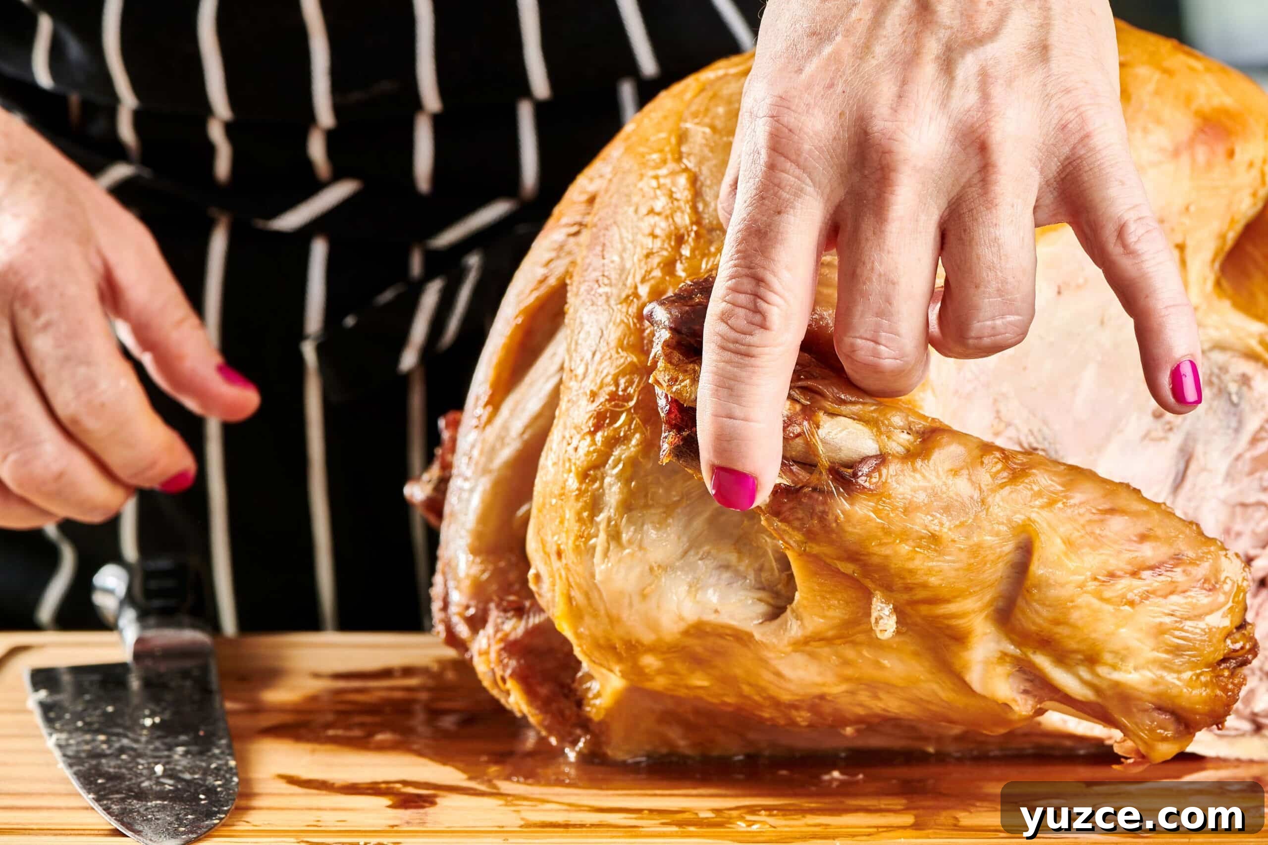 Perfect Turkey Carving Guide: Step-by-Step Tips for Juicy Slices 6 Woman removing turkey wings from a roast turkey.