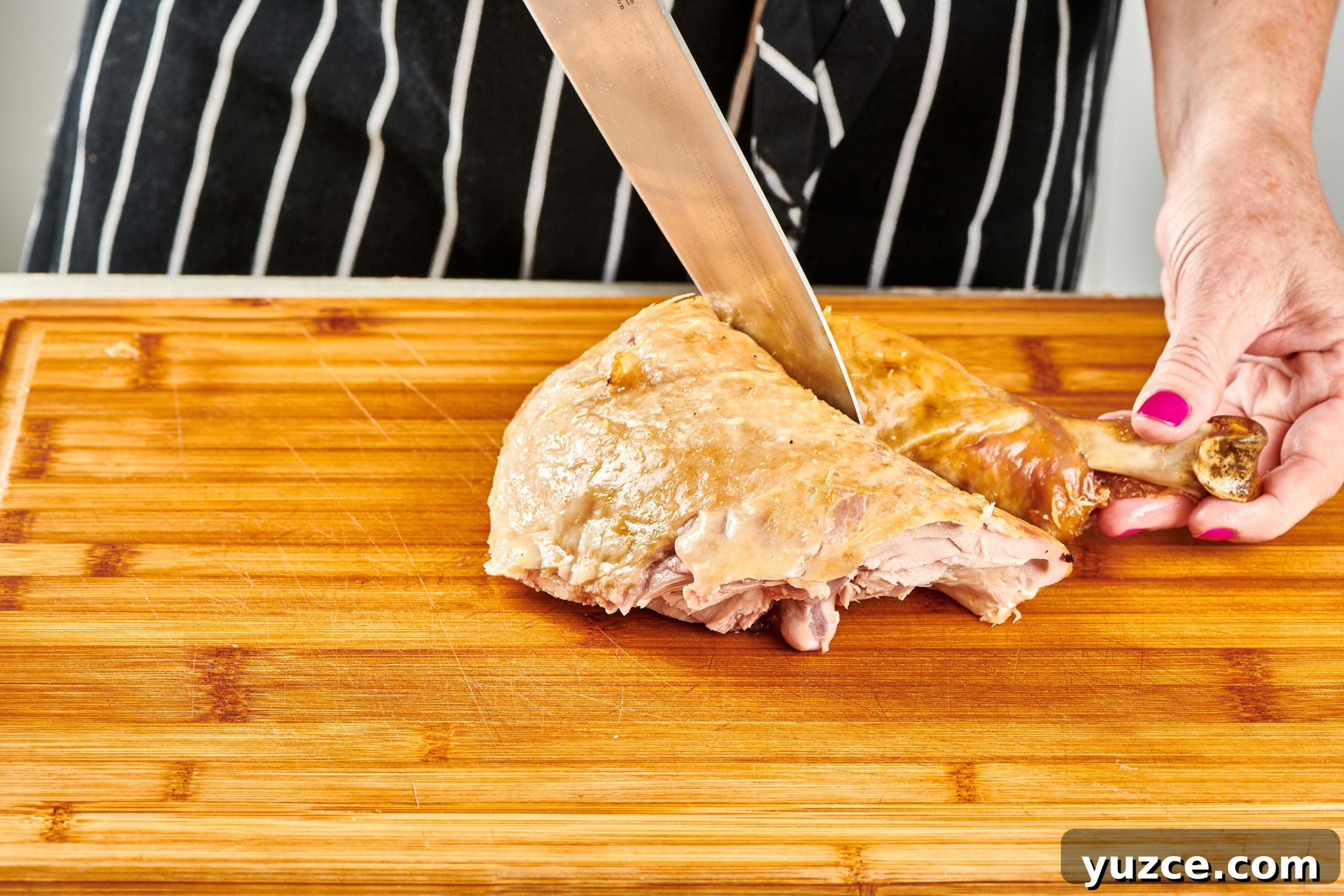 Perfect Turkey Carving Guide: Step-by-Step Tips for Juicy Slices 8 Woman separating turkey thigh and drumstick with a knife