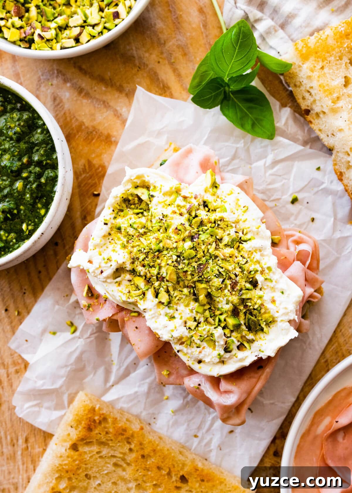 Classic Italian Mortadella Sandwich Recipe — Quick Lunch Idea 12 How to make Mortadella Sandwich Recipe with Pistachio Pesto and Burrata (step-by-step): adding crushed pistachios on top of the burrata cheese.
