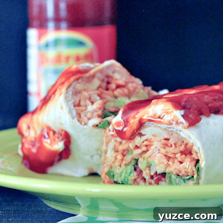 a homemade version of a Honkin' Huge Burrito, a large burrito sliced in half to show ingredients: beans, rice, greens, cheese, and sweet saucy stewed tomatoes on top.