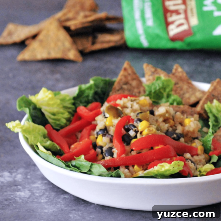 burrito bowls in a shallow bowl: greens, cauliflower rice, beans, red peppers