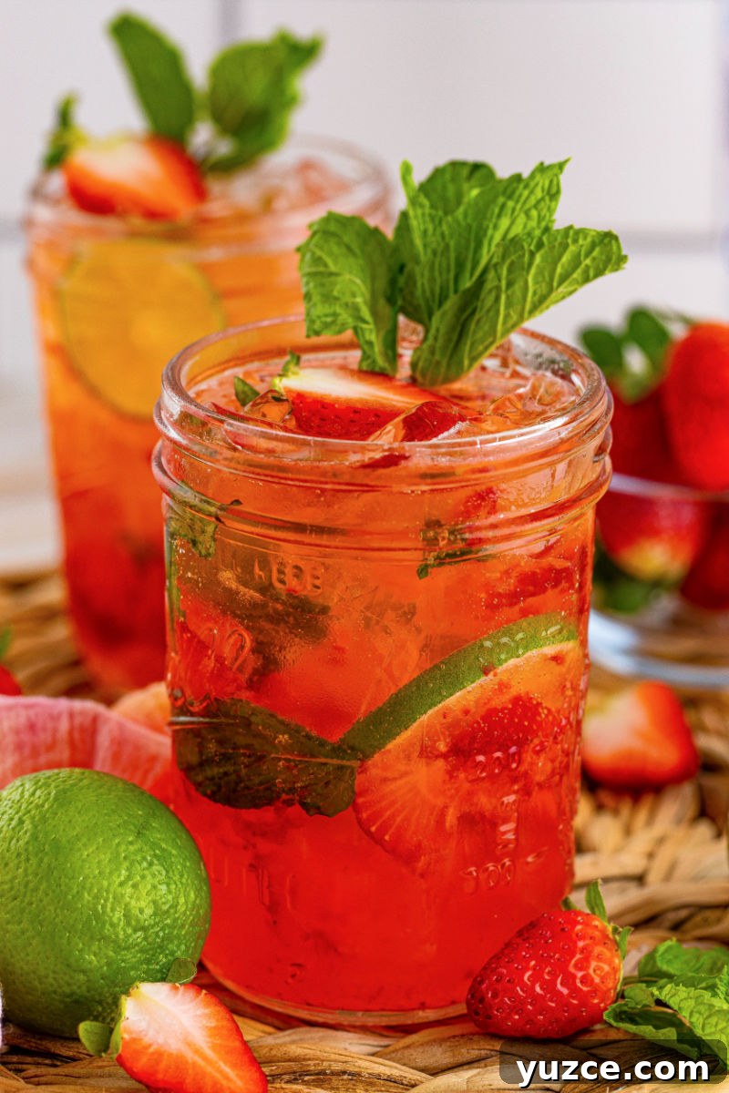 Strawberry Vodka Smash: Refreshing Summer Cocktail Recipe 2 close up of a strawberry vodka smash cocktail garnished with strawberries and mint