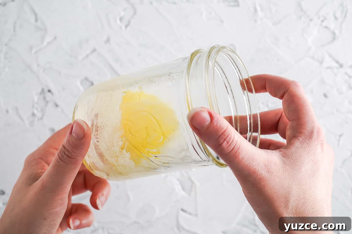 Warm Apple Cinnamon Mug Cake Recipe for One 8 Two hands holding glass with melted butter inside