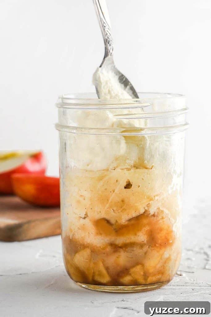 Warm Apple Cinnamon Mug Cake Recipe for One 9 Side view of apples cake and whipped cream in a glass jar with spoon