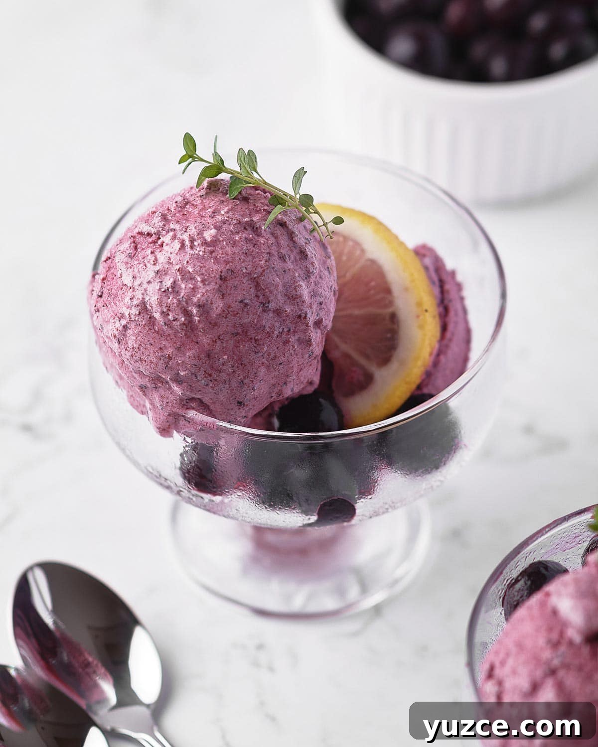 Blueberry Sherbet Recipe: Refreshing Homemade Frozen Treat 3 Melting scoop of blueberry sherbet in glass cup.