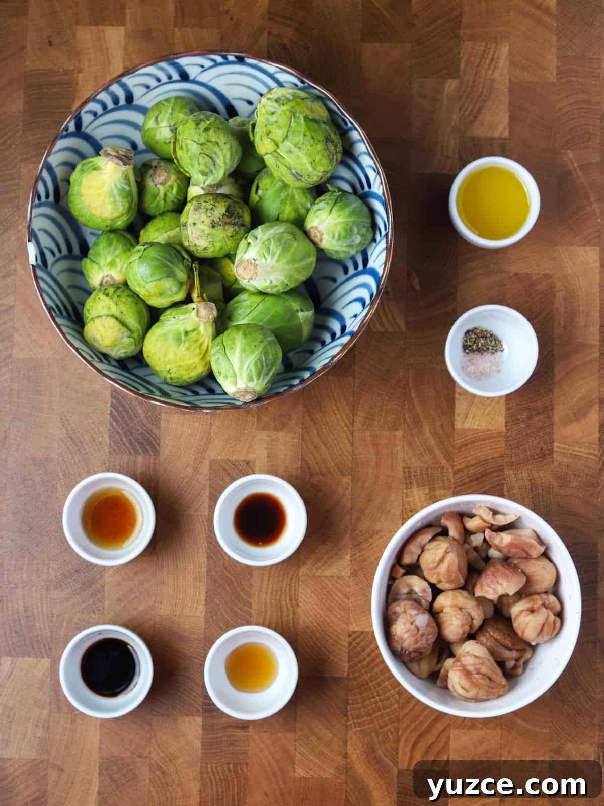 Smoky Roasted Brussels Sprouts with Chestnuts (Vegan) 3 Photo of the ingredients for this vegan roast sprout and chestnut dish, all laid out in bowls on a wooden work surface.