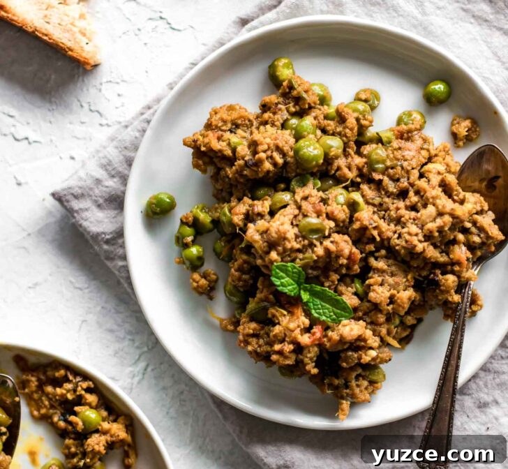 Keema Matar: Spiced Ground Beef and Pea Curry Recipe 13 Keema Matar on a gray napkin with bread on the side
