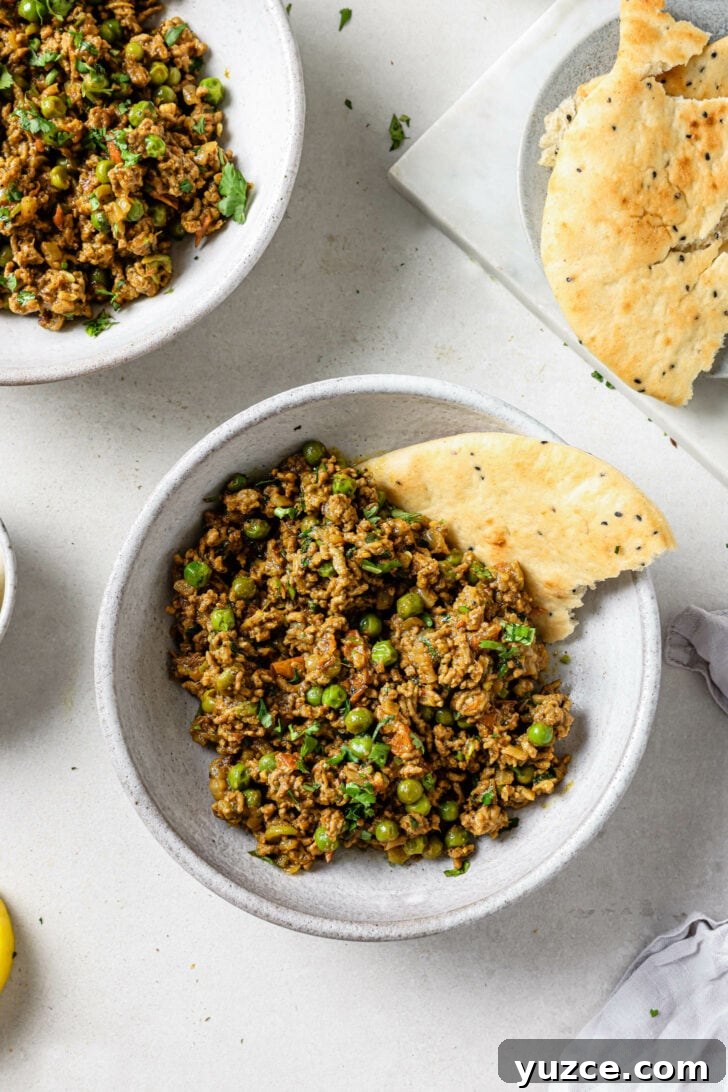 Keema Matar: Spiced Ground Beef and Pea Curry Recipe 6 Keema Matar in a bowl with a piece of naan.