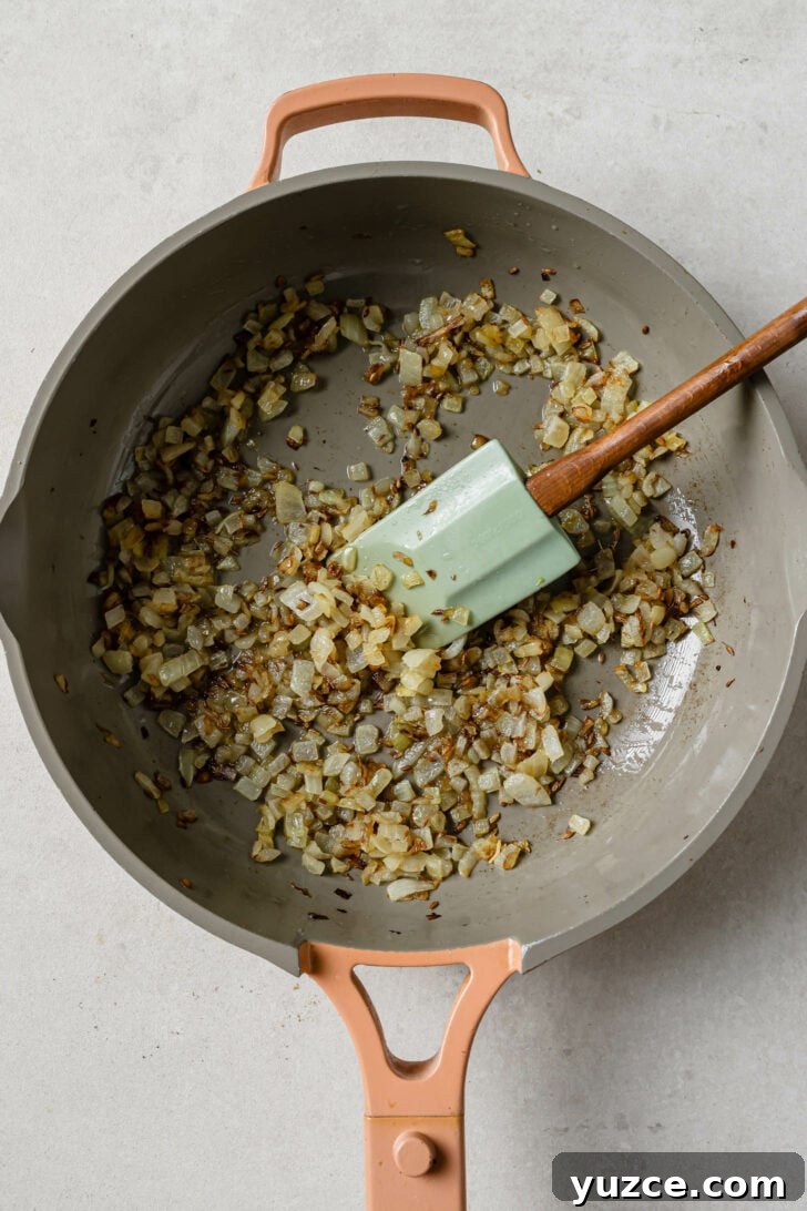 Keema Matar: Spiced Ground Beef and Pea Curry Recipe 7 Sauteed onions and cumin seeds in a skillet for Keema Matar.