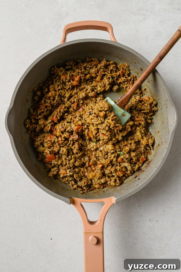 Keema Matar: Spiced Ground Beef and Pea Curry Recipe 9 Skillet with sauteed beef, tomatoes, green chili, yogurt and spices for Keema Matar.
