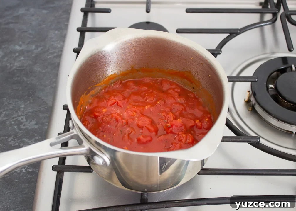 Tomato Baked Eggs with Ham Recipe: Savory One-Pan Breakfast 5 Garlic and tinned tomatoes in a saucepan