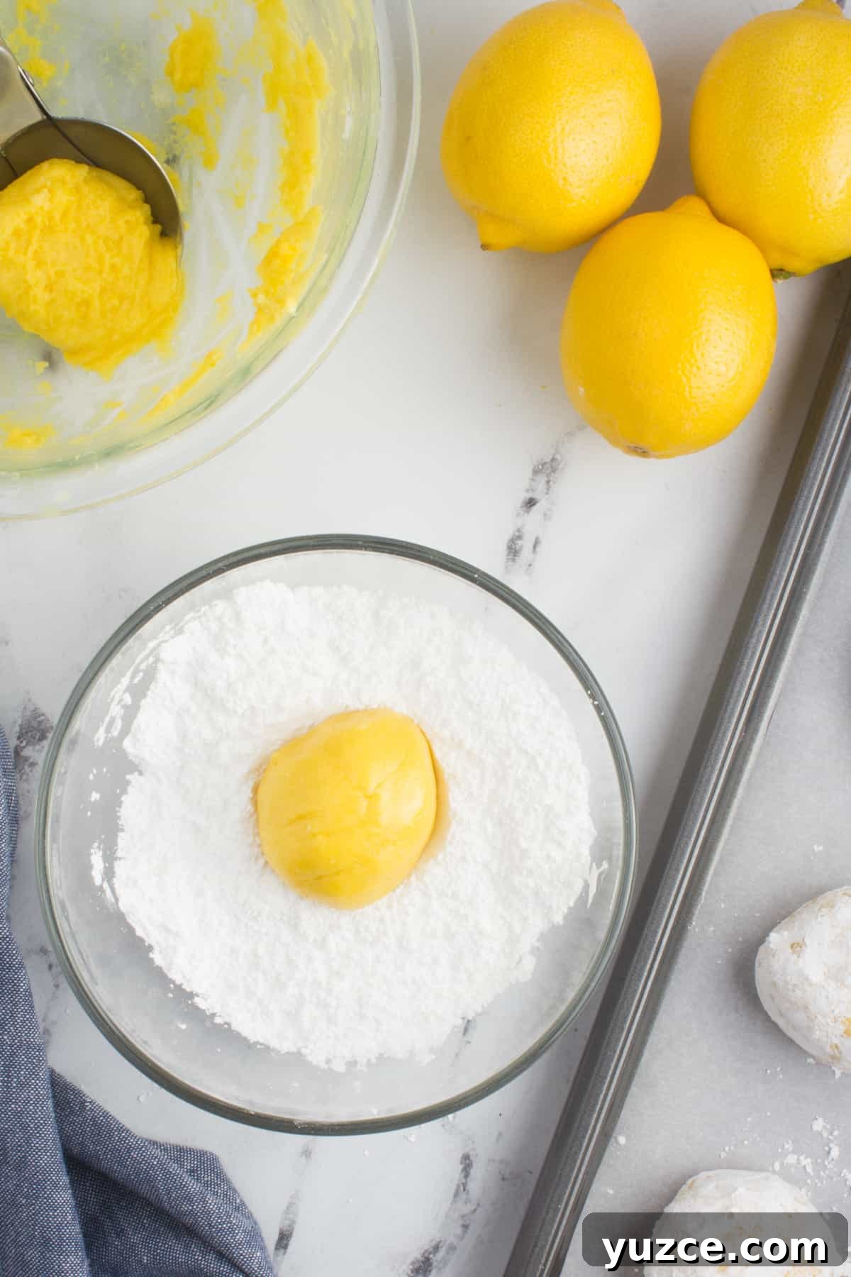 Chewy Lemon Cake Mix Cookies: Quick Citrus Cookie Recipe 7 an arrangement of lemons, lemon cookie dough in a bowl, and powdered sugar in a bowl with a lemon, sitting on a baking sheet lined with parchment paper