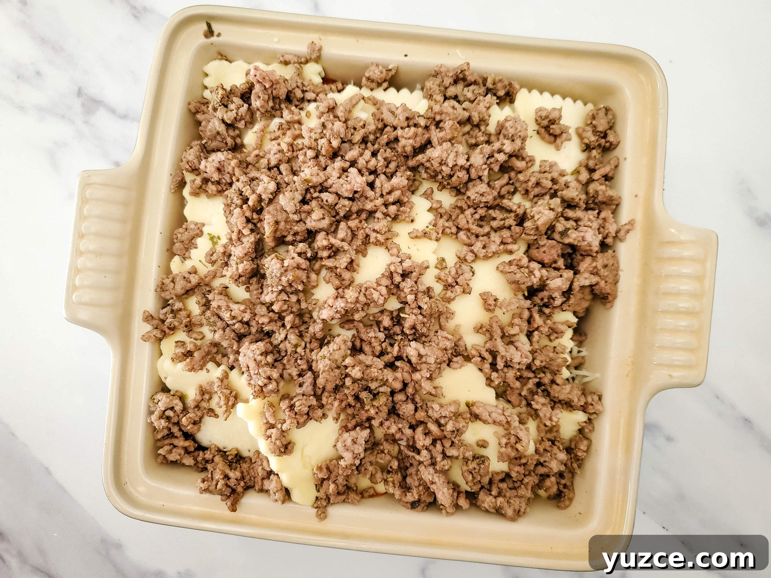 Quick Ravioli Lasagna Recipe for Busy Weeknight Dinners 8 Neutral colored baking dish with frozen ravioli lasagna layers