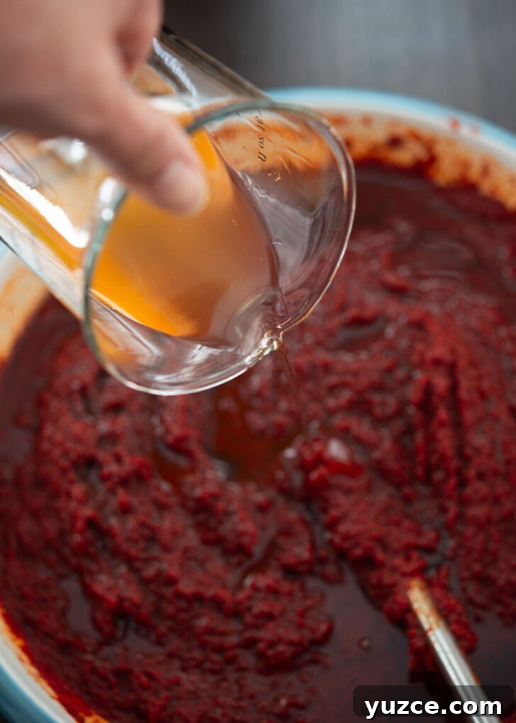 Quick 10-Minute Homemade Gochujang Recipe 11 Korean plum extract added to chili paste mixture in a bowl.