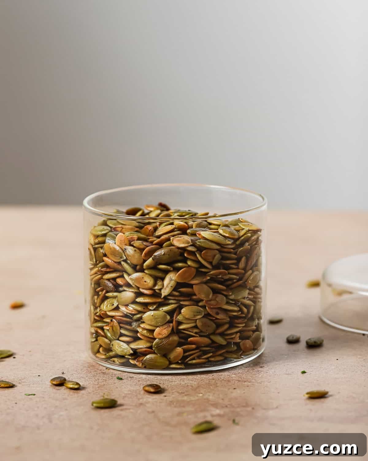 Crispy Oven-Roasted Pepitas with Sea Salt 13 glass jar filled with roasted pepitas on a table.