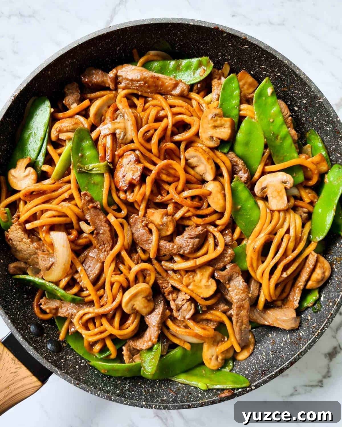 Beef Noodle Stir-Fry with Garlic and Sesame Sauce 2 Cooked stir fried noodles in a black pan