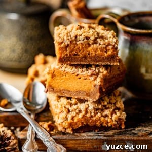 sweet potato pie bars stacked on top of each other on a wooden board.