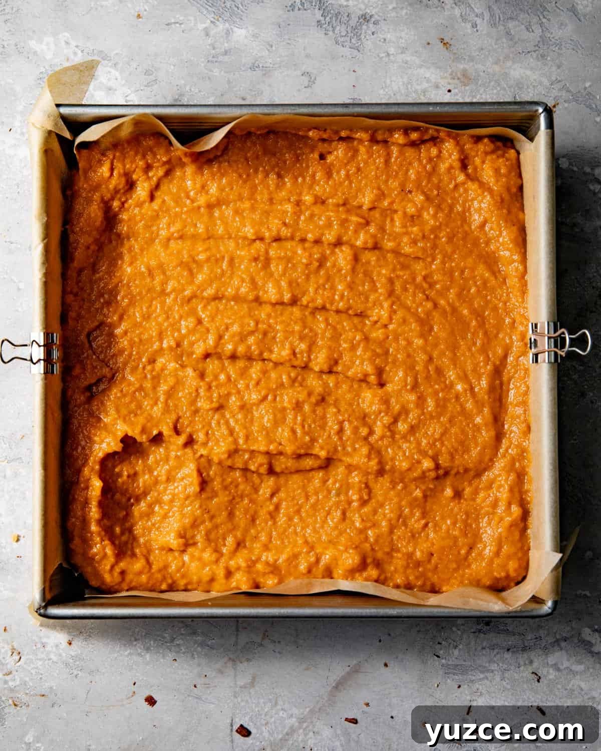 sweet potato pie filling poured into a pan atop the biscoff crust.