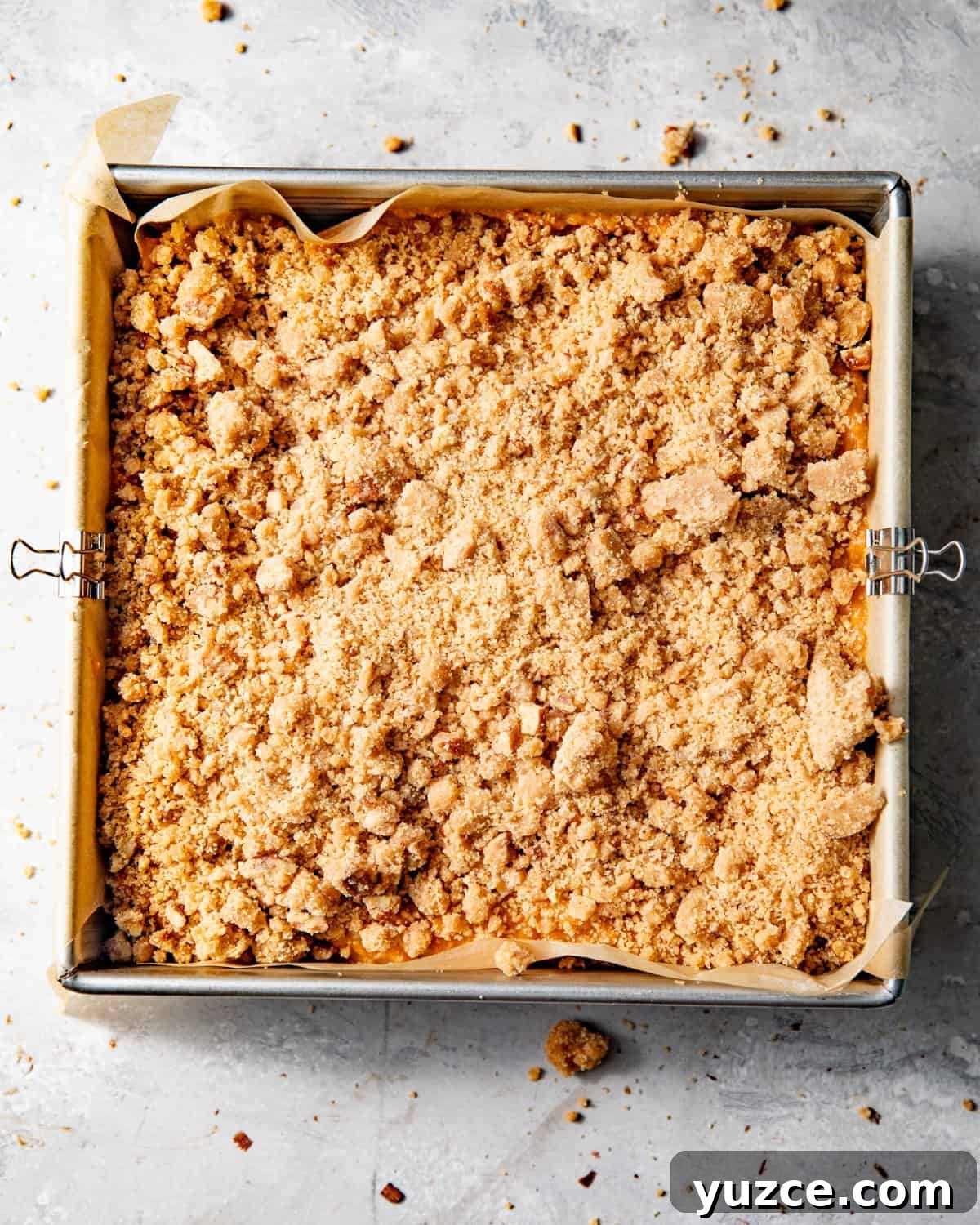sweet potato pie bars covered in pecan streusel prior to baking in the oven.
