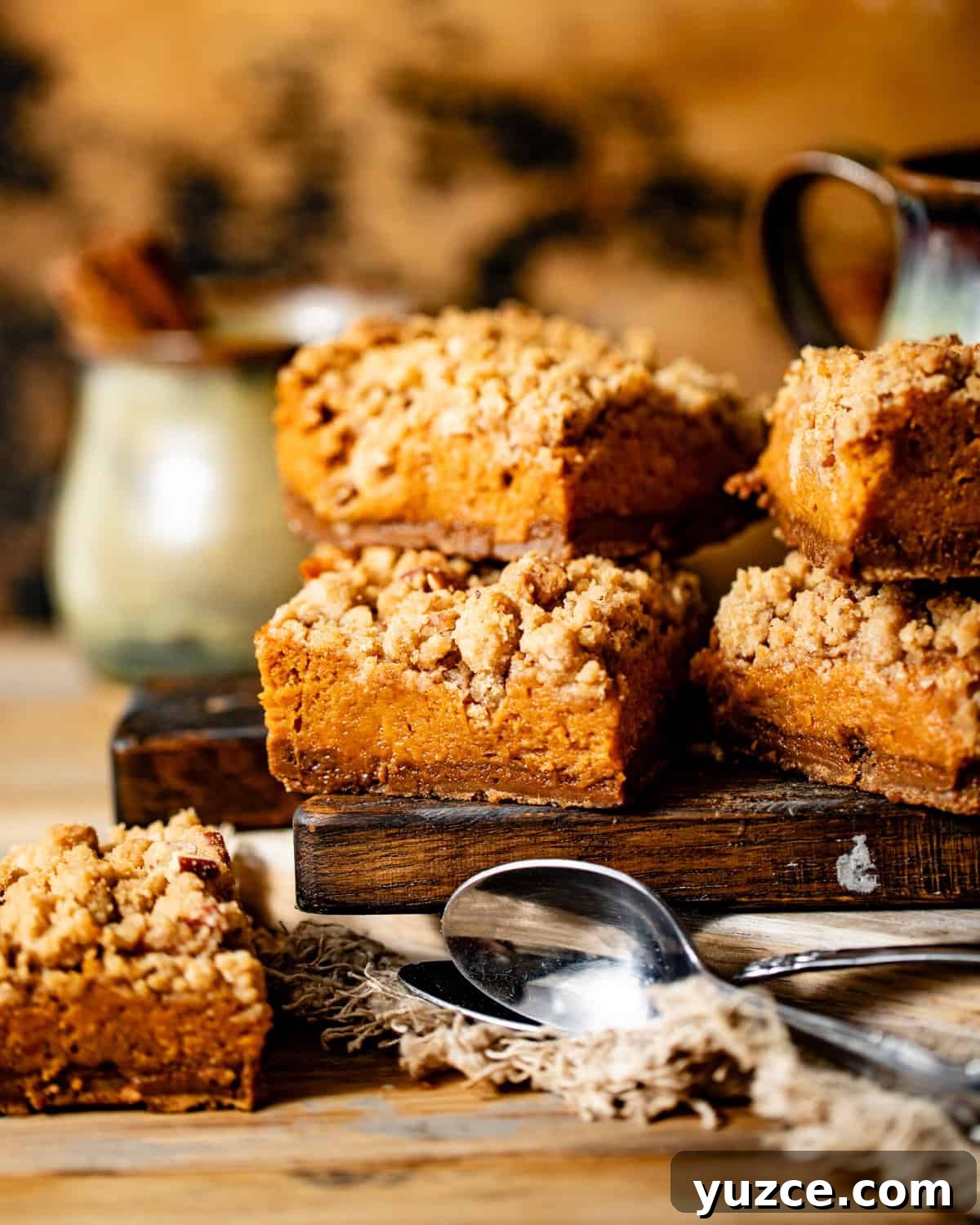 sweet potato pie bars cut into squares on a wooden board with spoons.