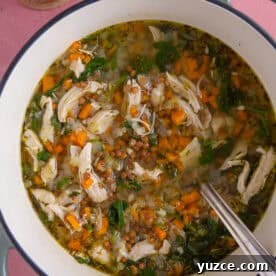 A pan of chicken and lentil soup with a side of gluten free bread.