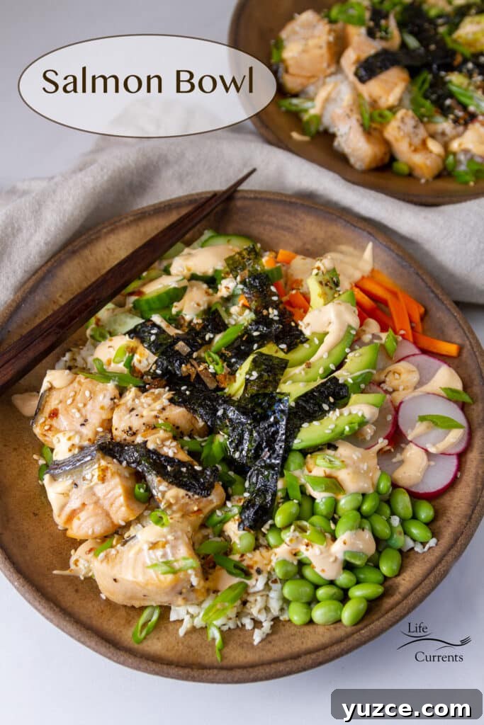 Grilled Salmon Bowl with Quinoa, Avocado & Citrus Dressing 2 Two salmon bowls in brown ceramic bowls one with chopsticks on the left side, a cloth napkin in the middle.