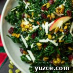 kale salad with cranberries, cheese, pumpkin seeds, and apples