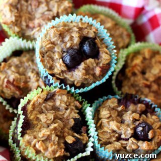 Brown bowl with a red and white checkered napkin containing 7 Baked Oatmeal Blueberry Oatmeal Cupcakes.