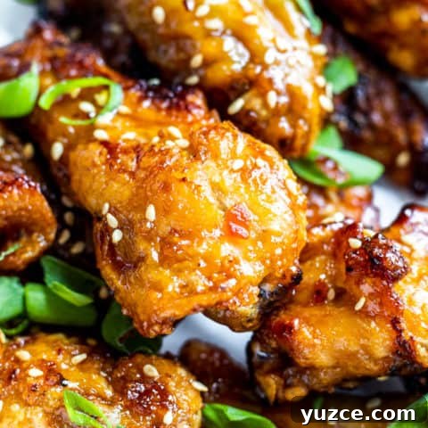 Close up shot of several chicken wings with sesame seeds.