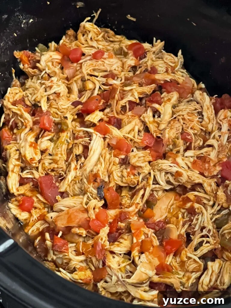 Crispy Baked Chicken Chimichangas with Cheesy Filling 5 Shredded Mexican chicken in the crock of a slow cooker.
