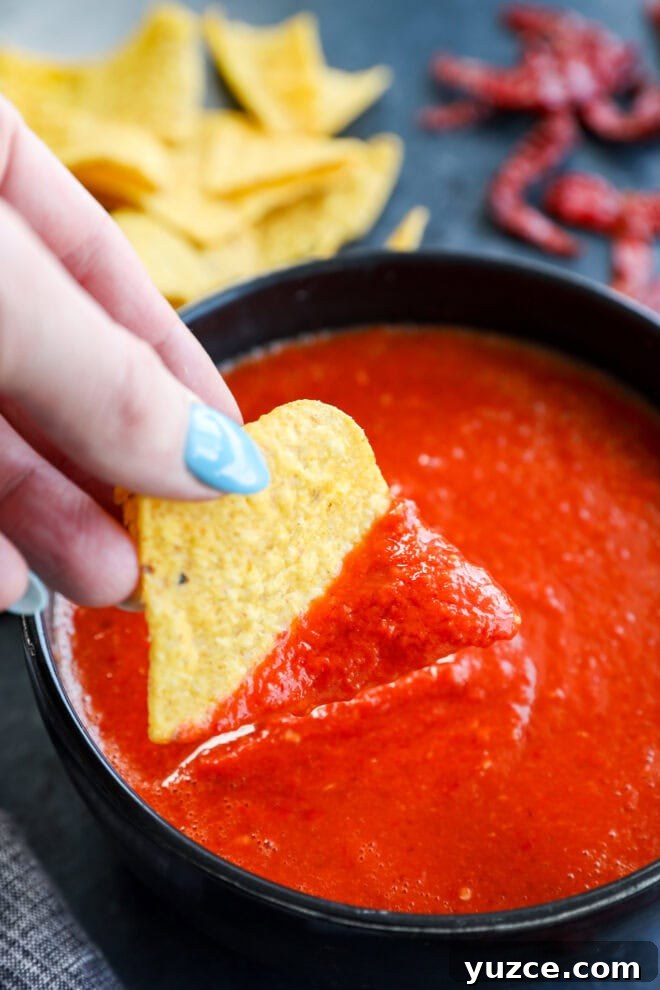 dipping a chip in chile de arbol salsa