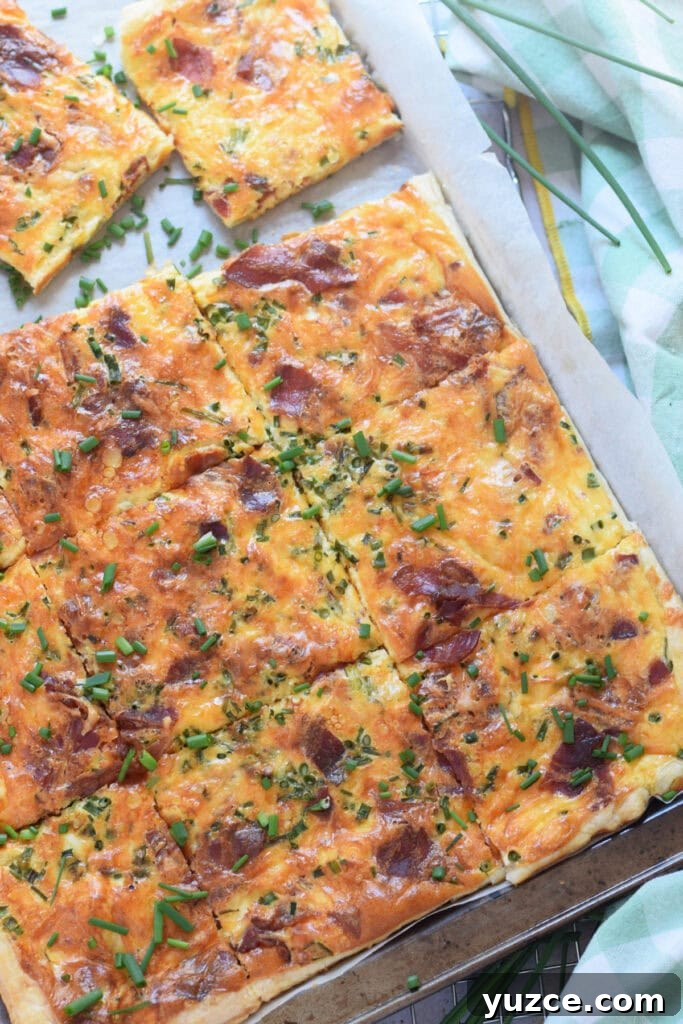 Flaky Puff Pastry Breakfast Quiche with Spinach and Cheese 12 Sheet pan breakfast quiche on a baking tray.