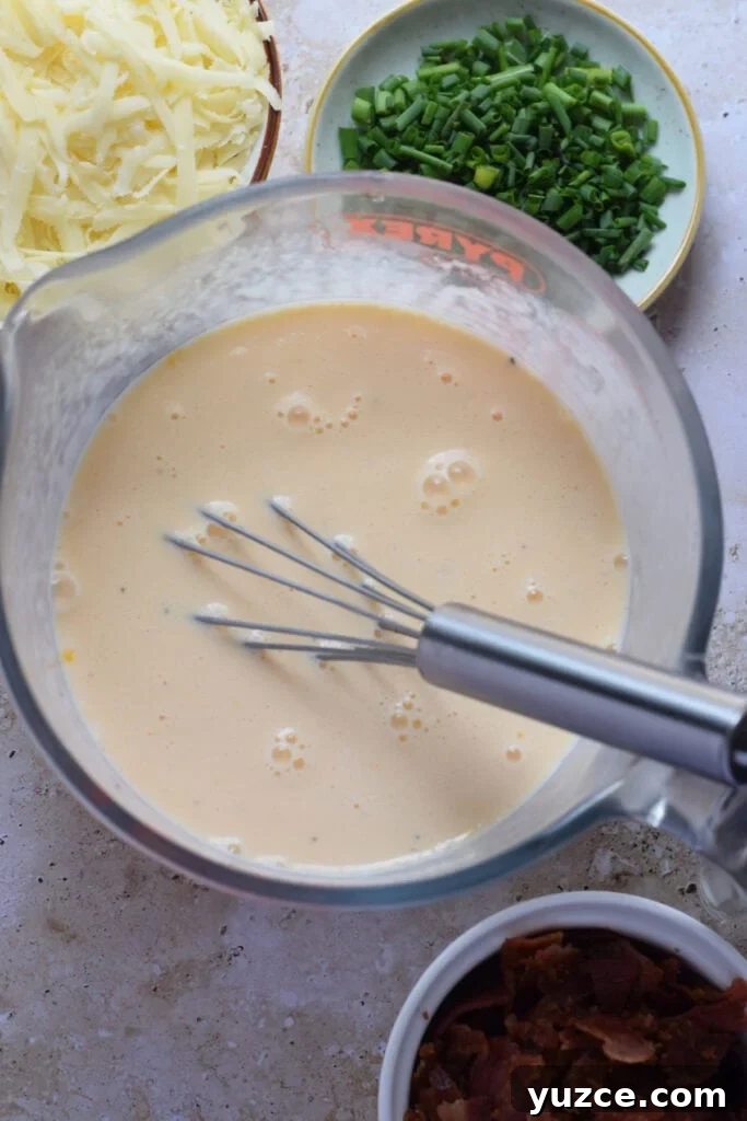 Flaky Puff Pastry Breakfast Quiche with Spinach and Cheese 6 Whisked eggs and cream in a measuring cup.