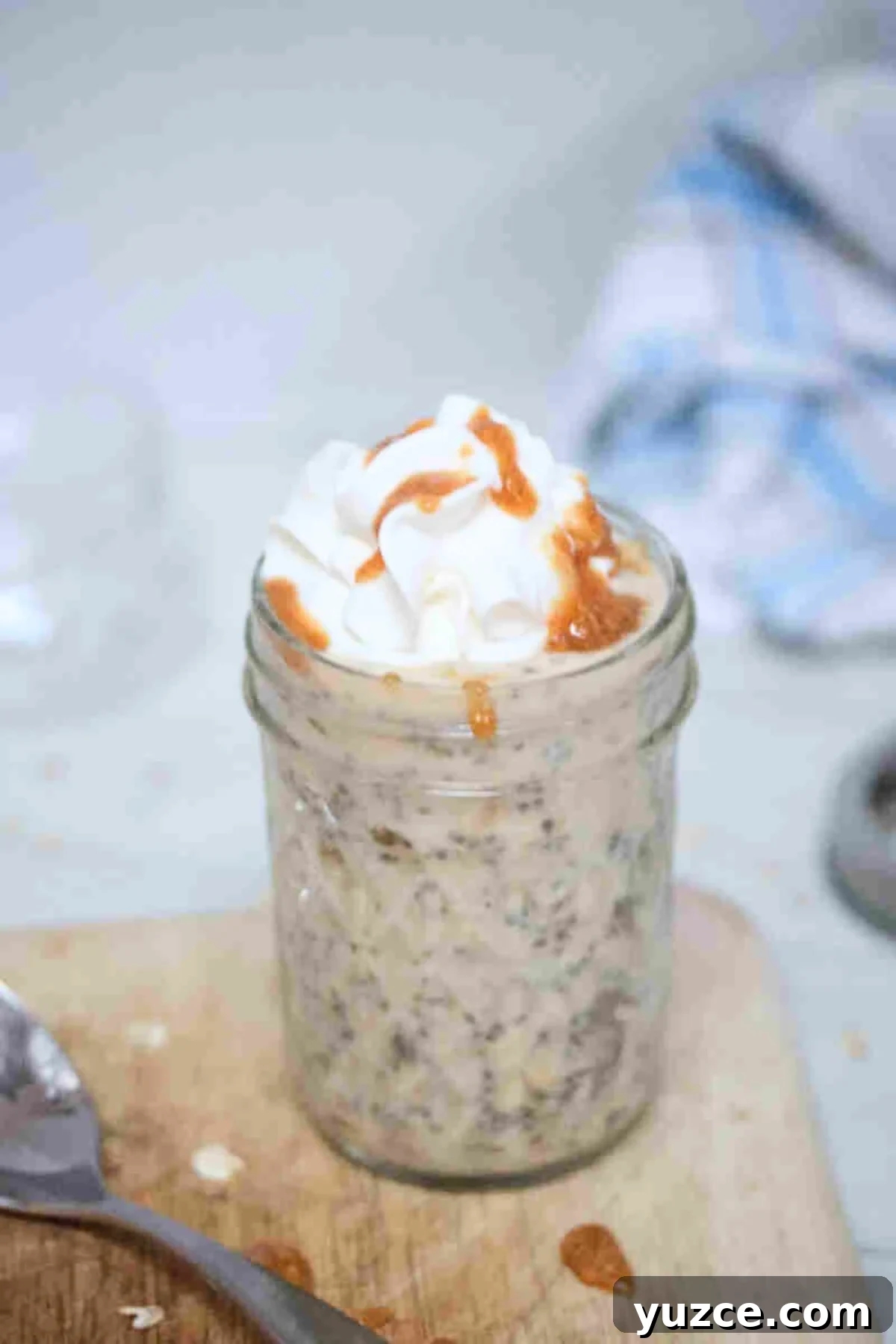 Protein-Packed Overnight Oats Recipe for Quick Breakfast 2 Mason jar with overnight protein powder oats topped with whipped cream and sauce.