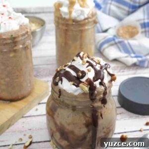 Protein-Packed Overnight Oats Recipe for Quick Breakfast 13 Three jars of overnight protein oats topped with whipped cream with a lid, cutting board and ingredients around them.