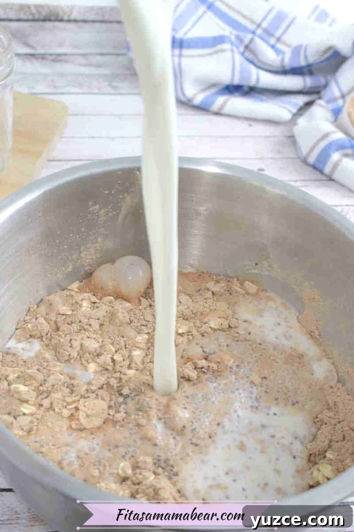 Protein-Packed Overnight Oats Recipe for Quick Breakfast 5 Almond milk being poured into a steel bowl with overnight oats mixture.
