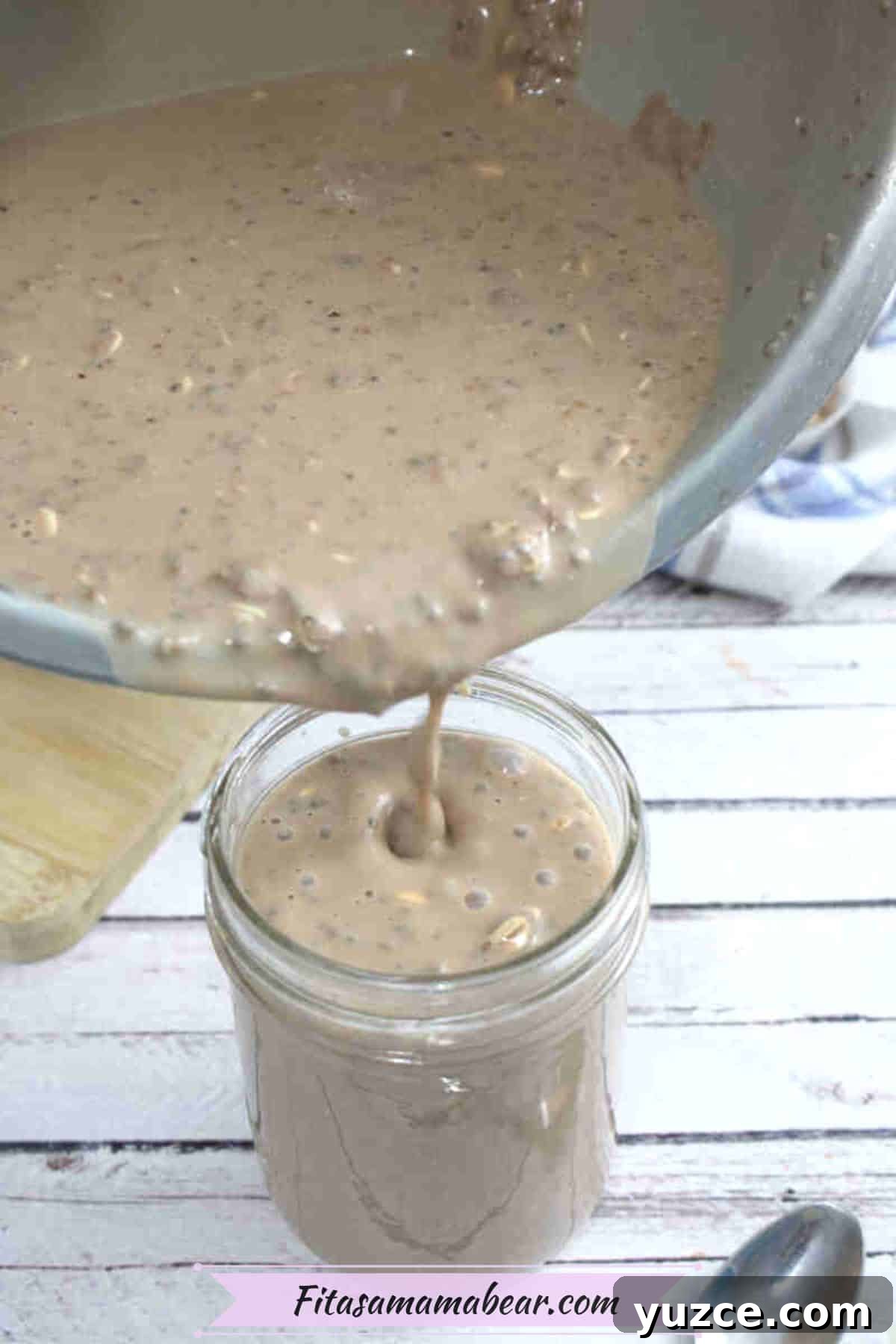Protein-Packed Overnight Oats Recipe for Quick Breakfast 6 Chocolate overnight oats with protein powder being poured from a steel bowl into a small mason jar.