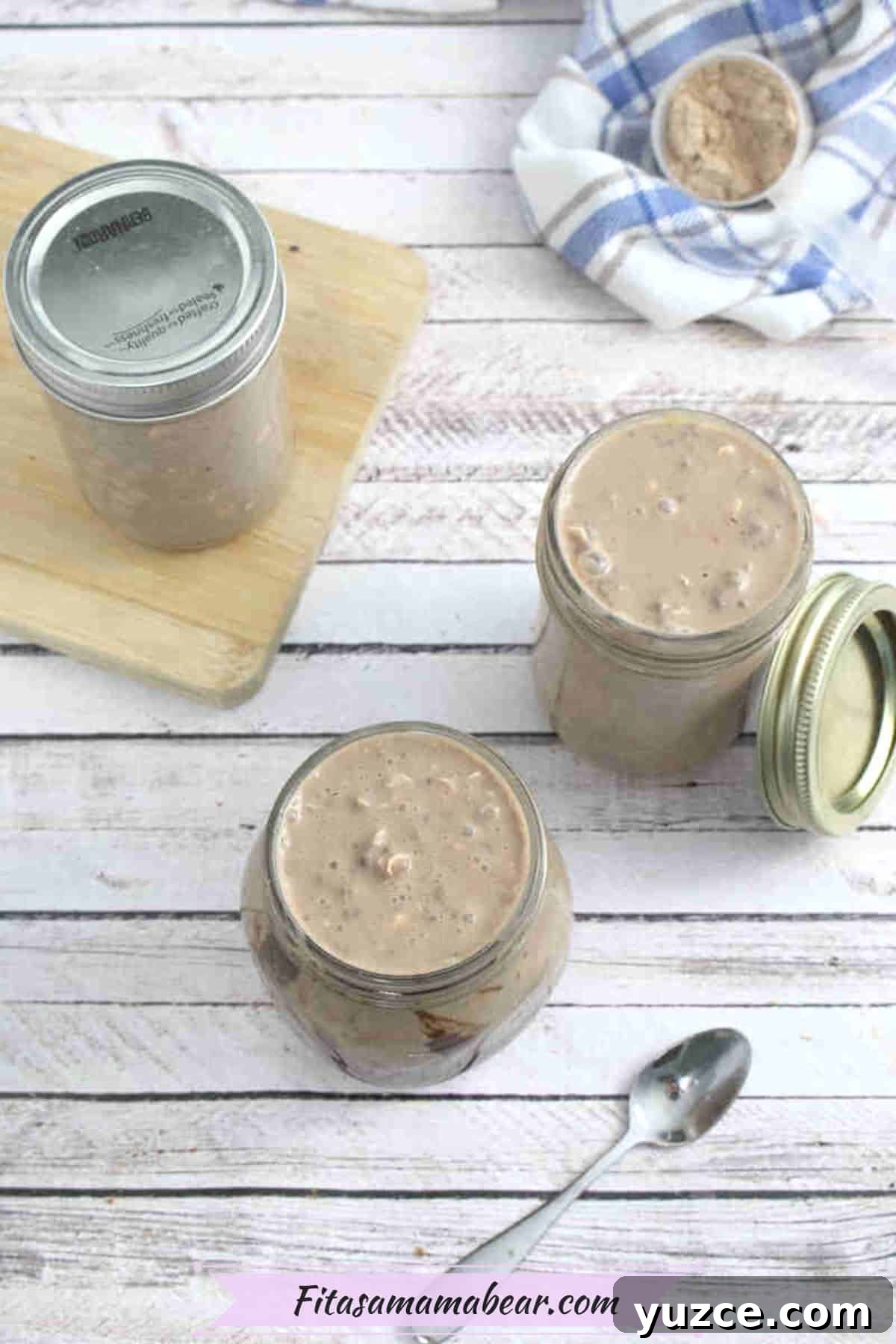 Protein-Packed Overnight Oats Recipe for Quick Breakfast 7 Two mason jars with chocolate protein overnight oats in them and one more behind them on a cutting board.