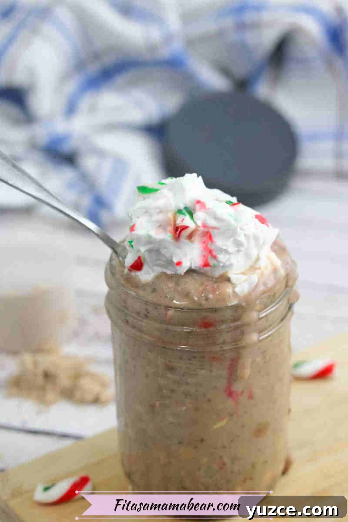 Protein-Packed Overnight Oats Recipe for Quick Breakfast 8 Mason jar with protein overnight oats topped with whipped cream and candy canes on a wooden cutting board.