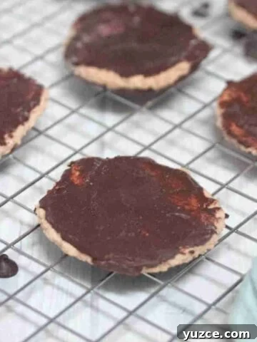 Chocolate coated protein thin mint cookies on a wire rack.